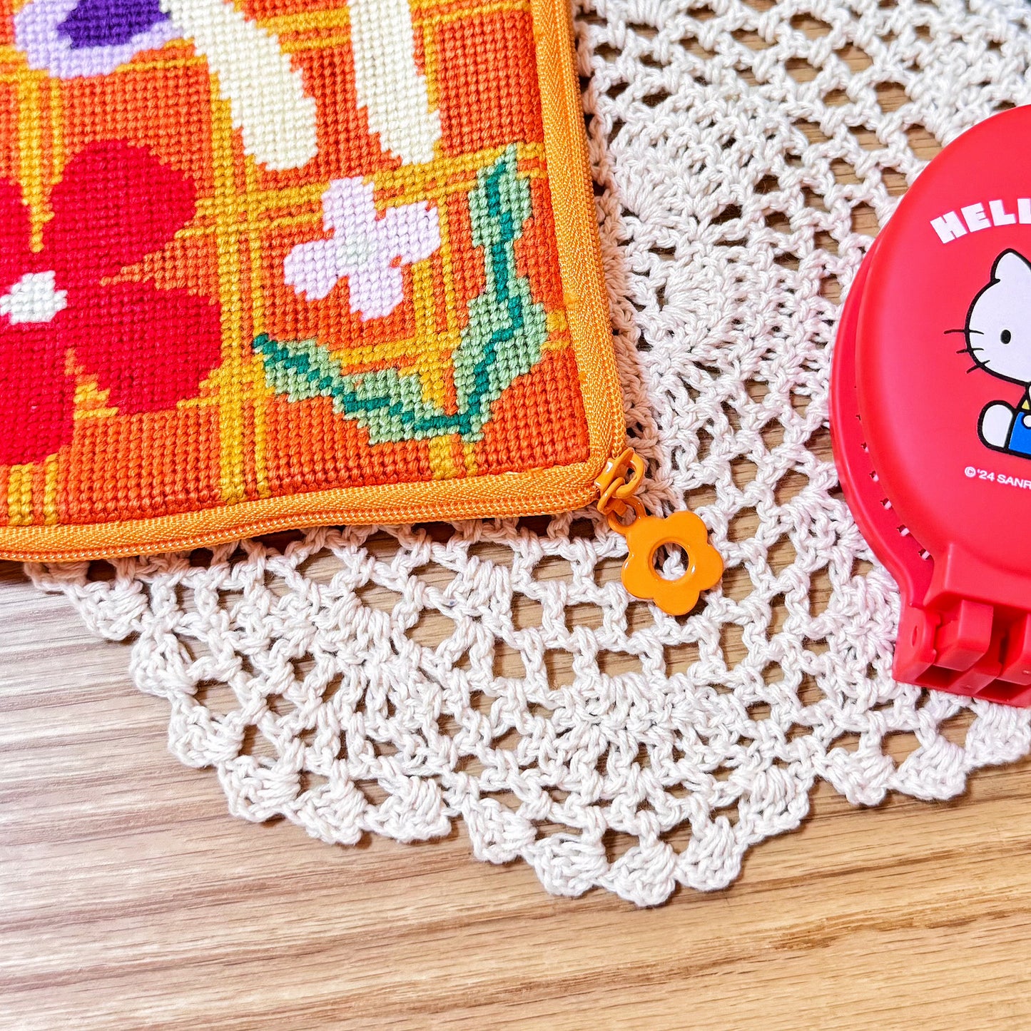 Detailed view of flower zipper puller and stitching on Bloom Daisy Half-Stitch Pouch