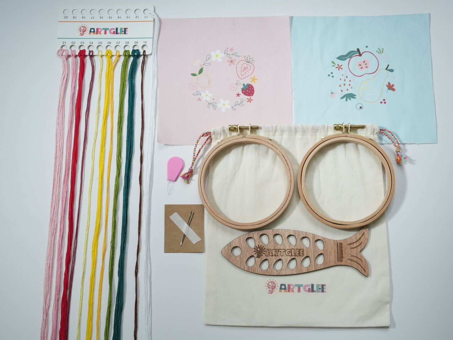 Full Fresh Picks embroidery kit contents with printed fabrics, colorful threads, fish-shaped thread board, hoops, and cotton bag.