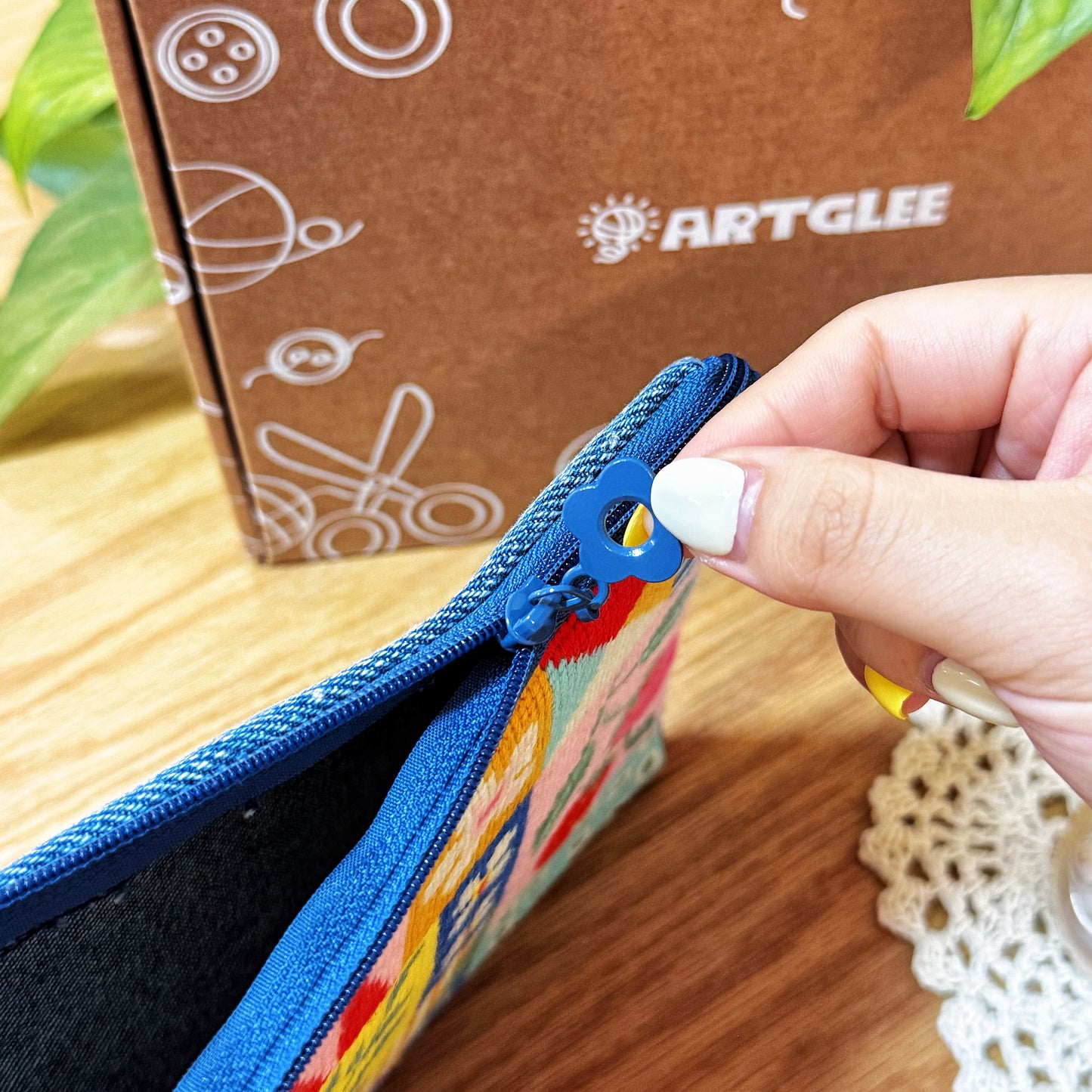 Detailed view of zipper being pulled on Patchwork Garden Half-Stitch Kit pouch