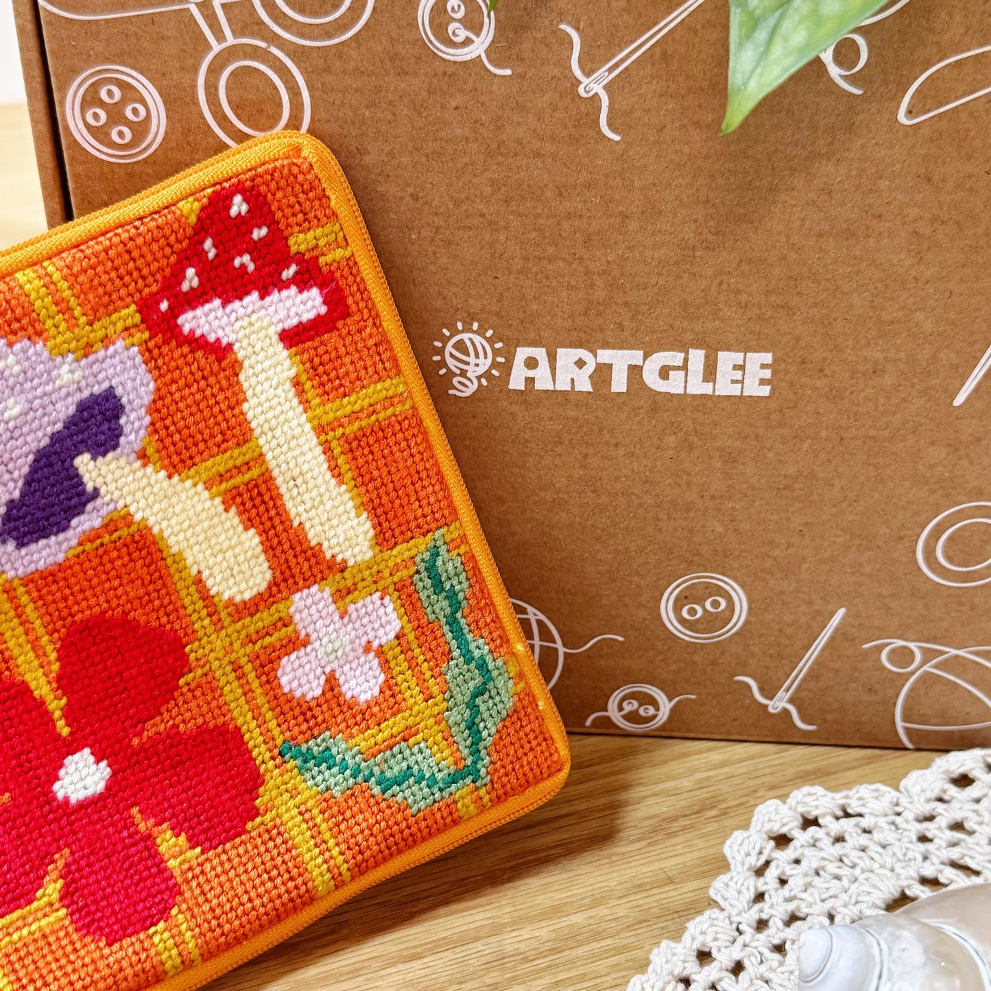 Close-up of Bloom Daisy Half-Stitch Pouch with Artglee kraft box packaging in background