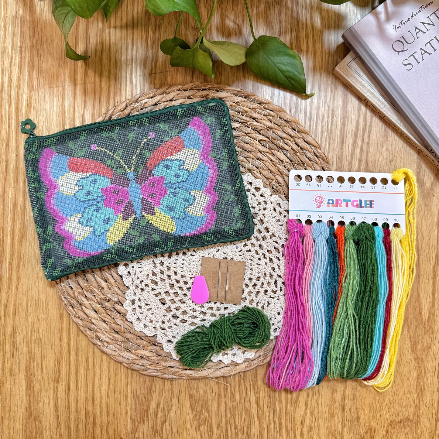 Complete Butterfly Garden Half-Stitch Kit set with unfinished pouch, embroidery threads, and tools arranged on a woven mat.
