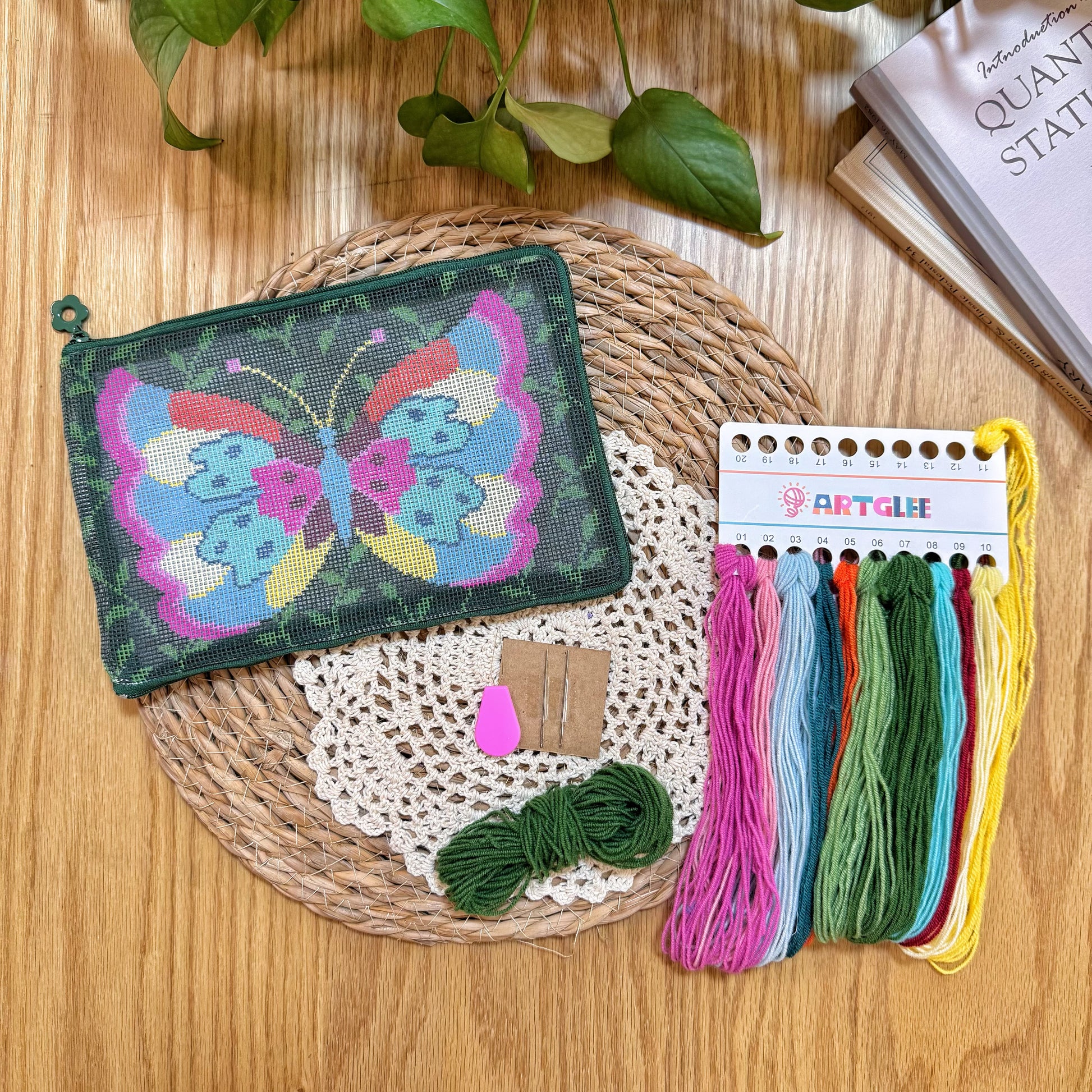 Complete Butterfly Garden Half-Stitch Kit set with unfinished pouch, embroidery threads, and tools arranged on a woven mat.