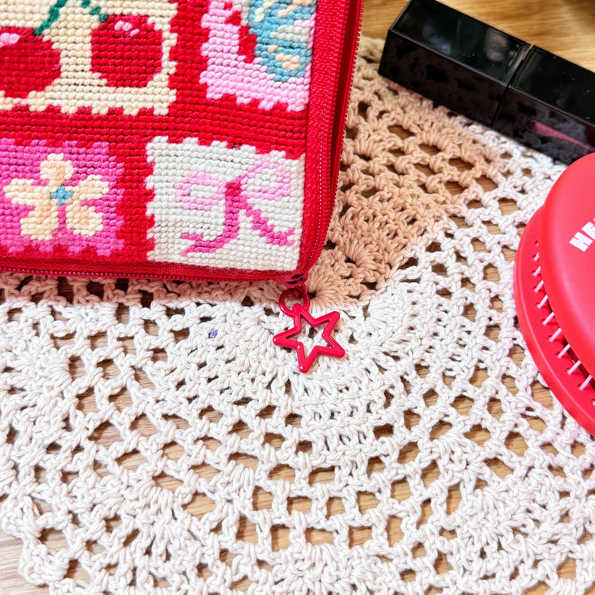 Cherry Love Half-Stitch Kit zipper close-up, red star-shaped zipper pull attached to pouch.