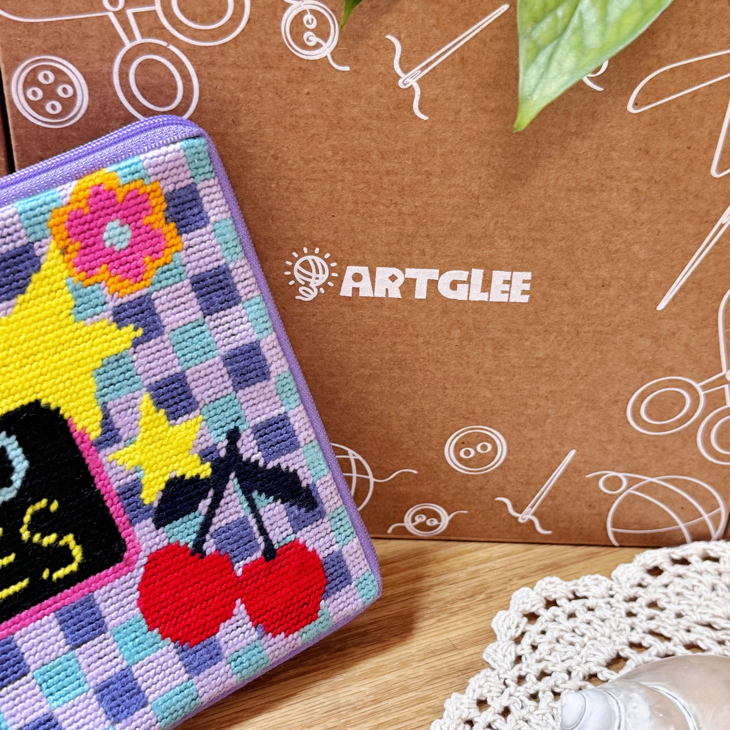 Good Times Half-Stitch Kit pouch placed beside an Artglee branded box, showing stitched cherry and flower details.