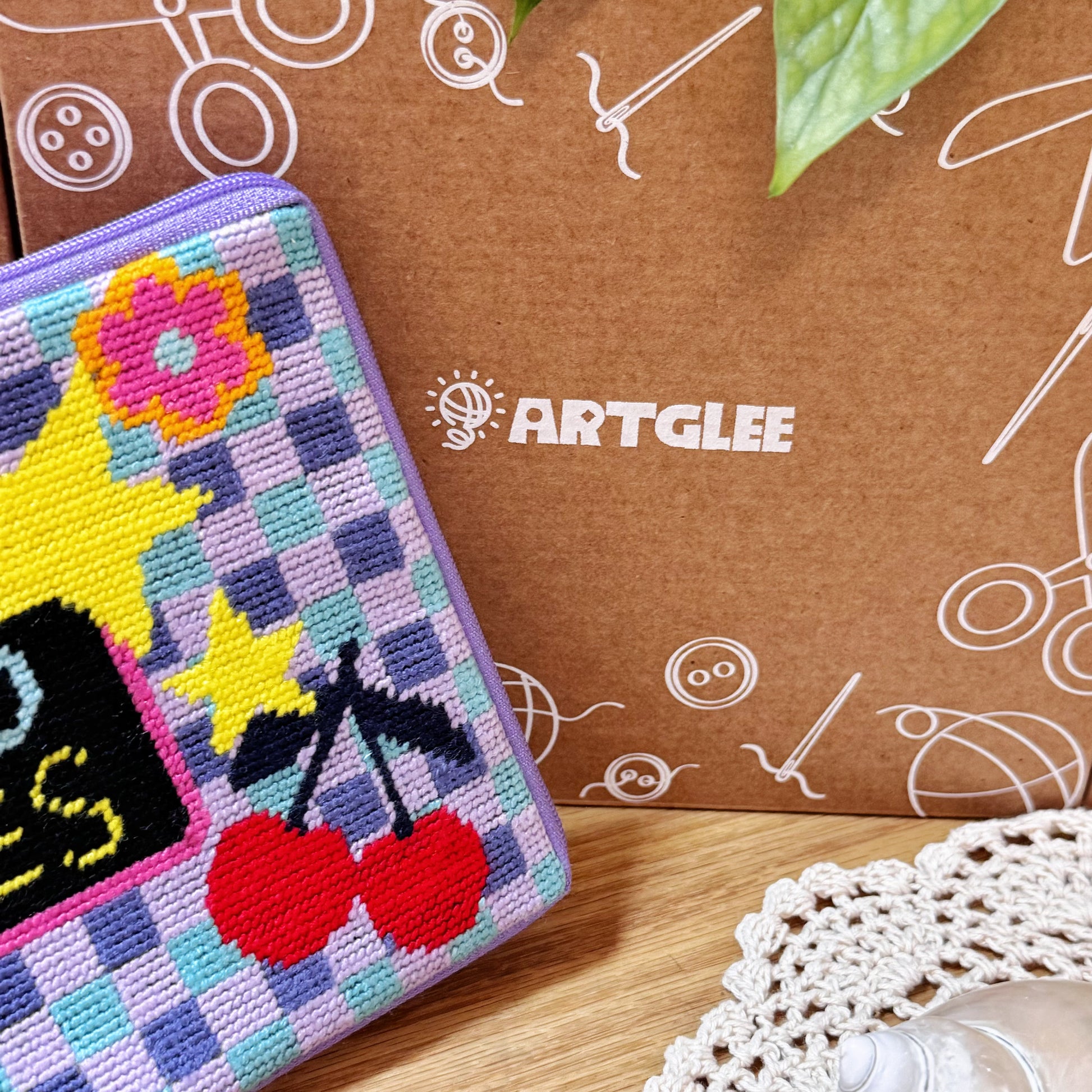 Good Times Half-Stitch Kit pouch placed beside an Artglee branded box, showing stitched cherry and flower details.