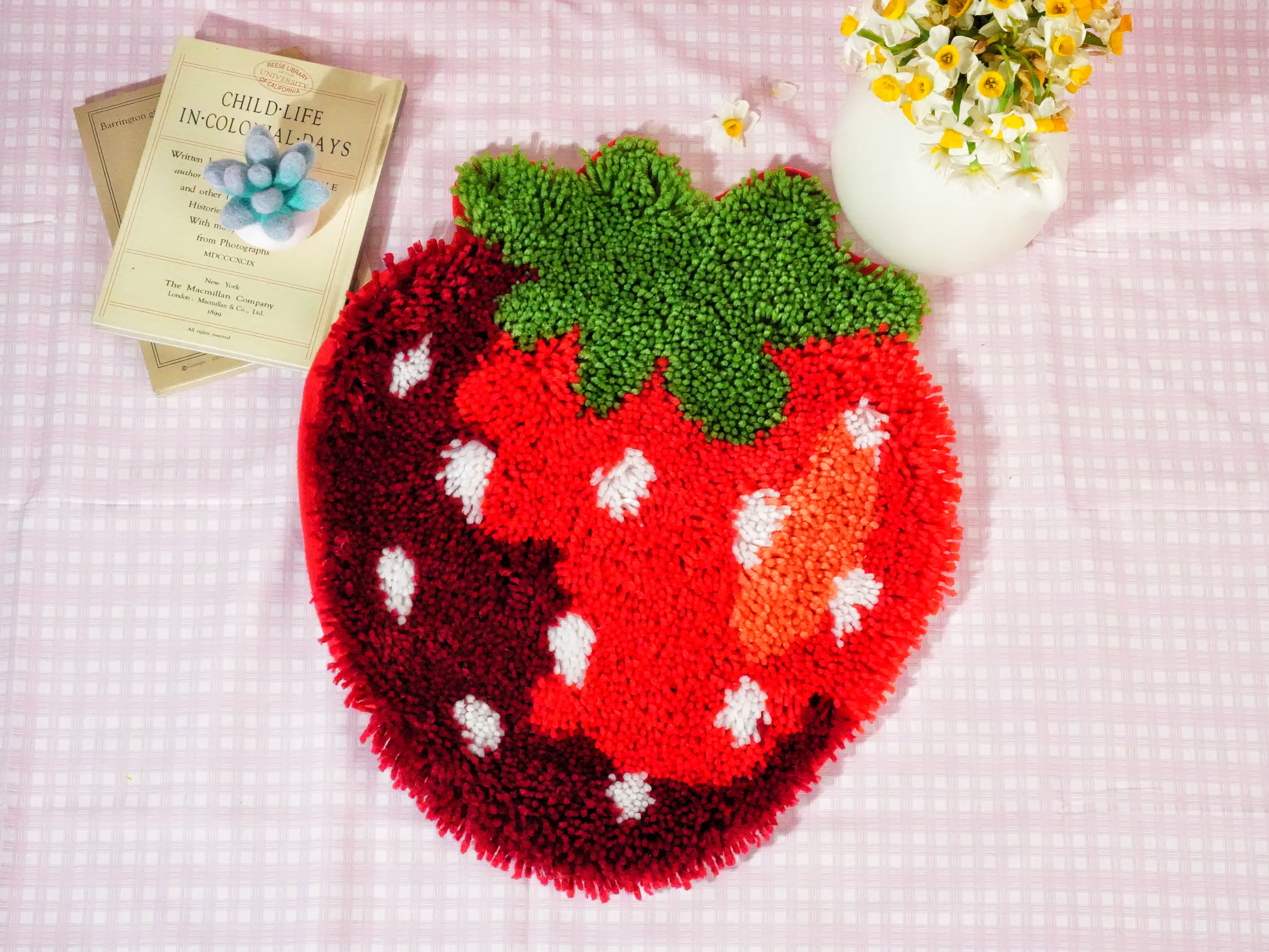 A strawberry-shaped latch hook design with a textured, tufted surface, representing the latch hook kit category.