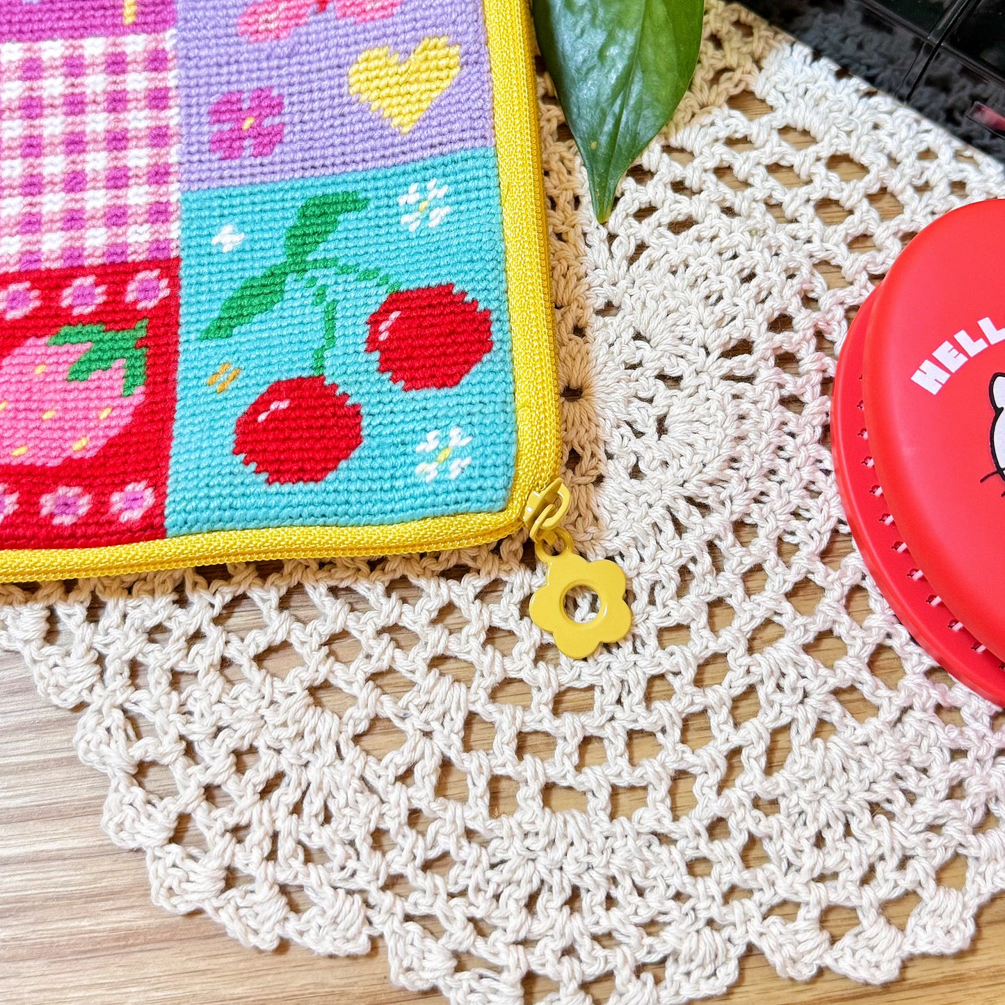 Close-up of yellow zipper with flower-shaped puller on Sunny Bloom patchwork pouch.