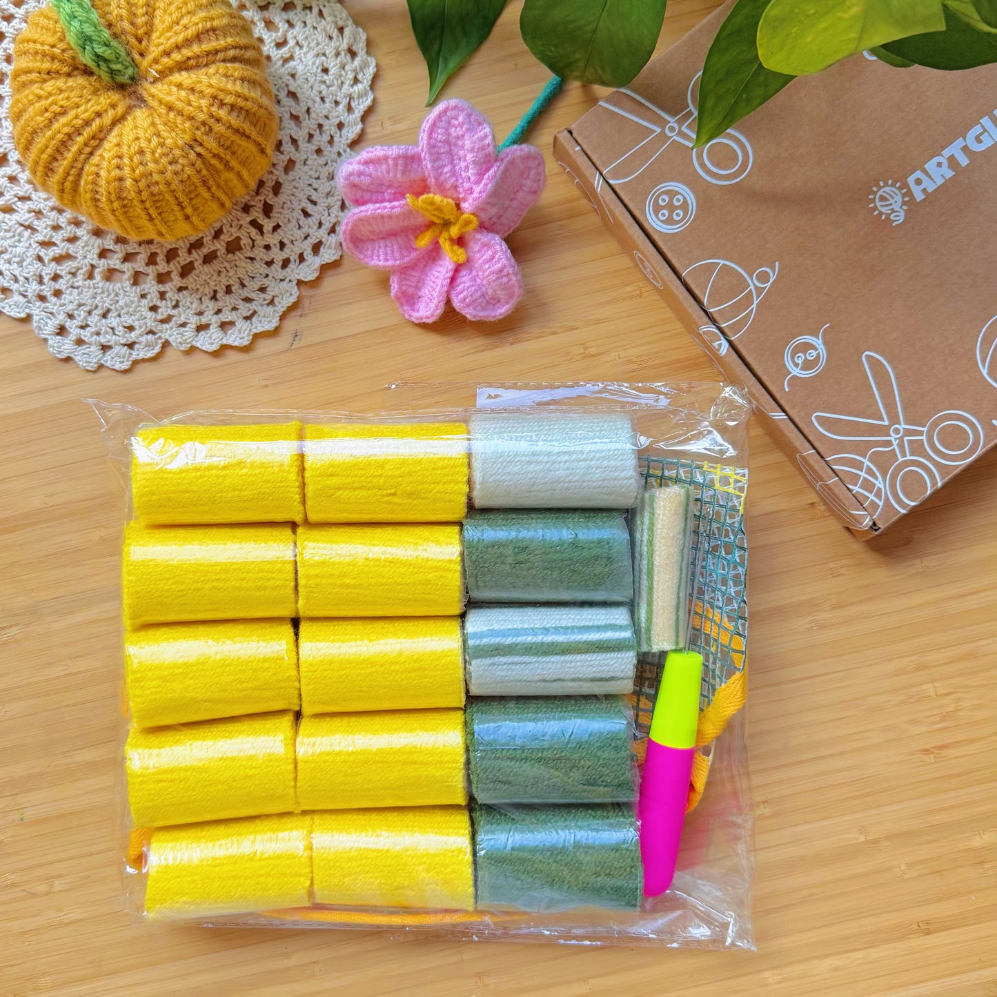 Packaged Sunny Lemon latch hook kit with yarn rolls, mesh canvas, and latch hook tool neatly arranged in clear plastic wrap.